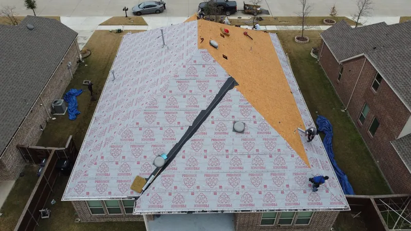 Drone view of a roof covered in synthetic underlayment before new shingles go on