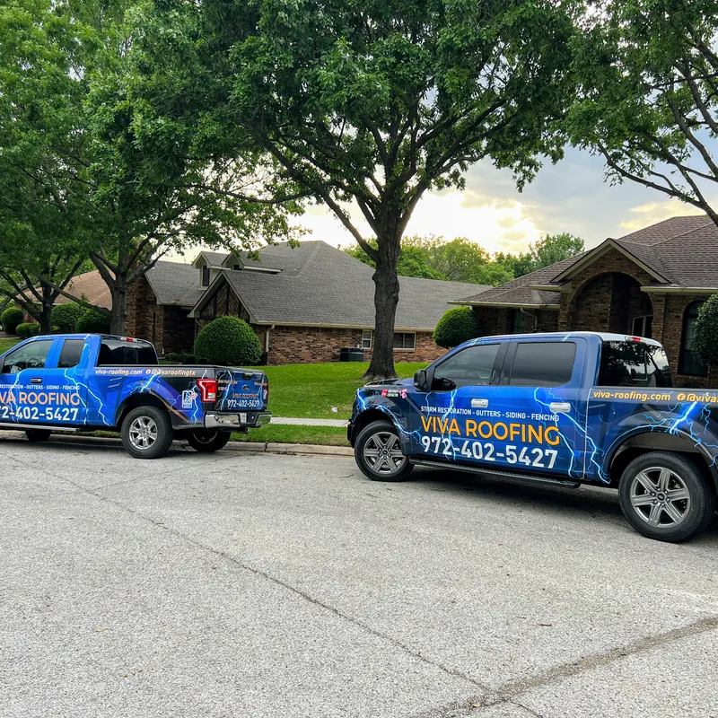 Blue Viva Roofing work trucks parked on a residential street